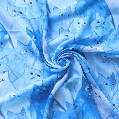 Blue scarf fabric with a charming cat illustration pattern in various blue and white tones. Soft, lightweight material.