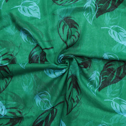 Aurora's Array: Close-up of a soft, lightweight green scarf with a large leaf print in shades of blue and black, swirled to show detail.