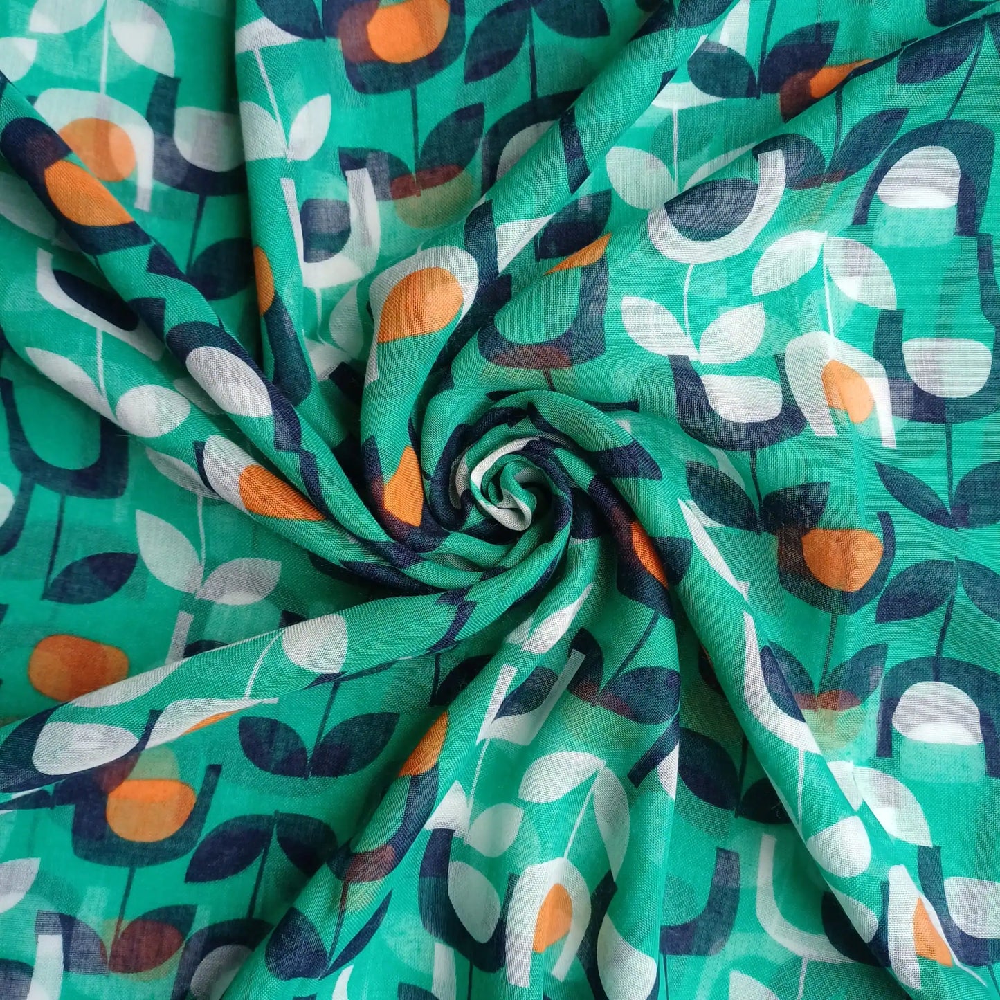Green abstract floral scarf styled in spiral fabric close up