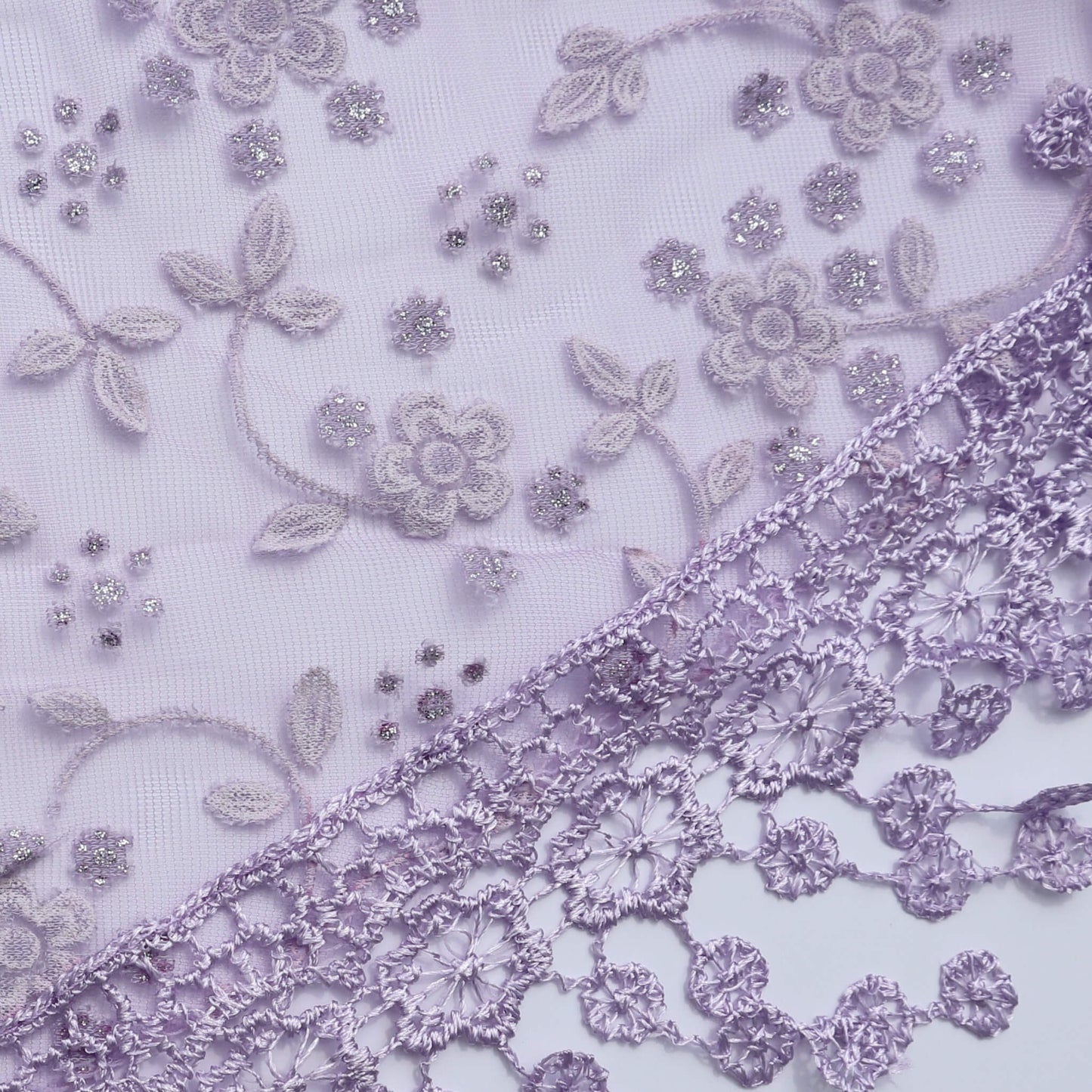 Aurora's Array Glitter Triangle Scarf with Lace & Embroidery (Close-up): A detailed close-up of a lilac, sheer fabric with delicate white floral embroidery accented with subtle glitter. The edge features intricate lilac lace trim with dangling embroidered