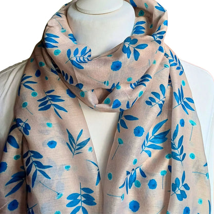 Beige scarf with blue floral pattern draped over a mannequin on a white background