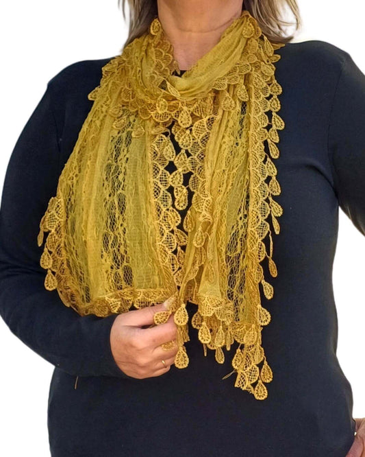 Aurora's Array: Woman models a mustard yellow lace scarf with a delicate leaf-like pattern and fringed edges.
