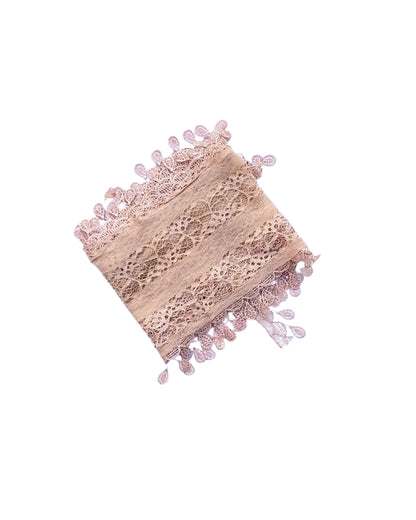 Aurora's Array: A soft nude beige lace scarf, folded to show its delicate leaf-like pattern and fringed edges.