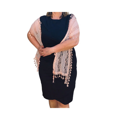 Aurora's Array: Woman models a soft peach-coloured lace scarf with a delicate leaf-like pattern and fringed edges.