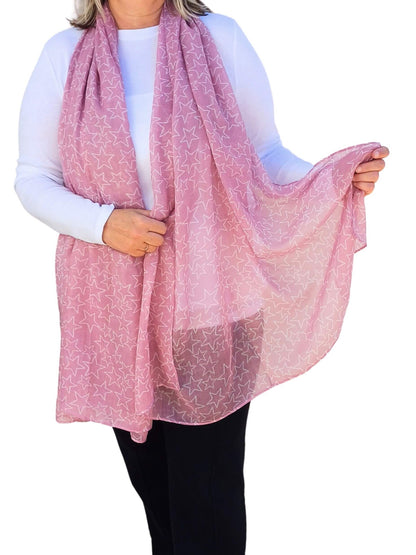 Aurora's Array: Woman models a soft, lightweight dusky pink scarf with a subtle white star print.