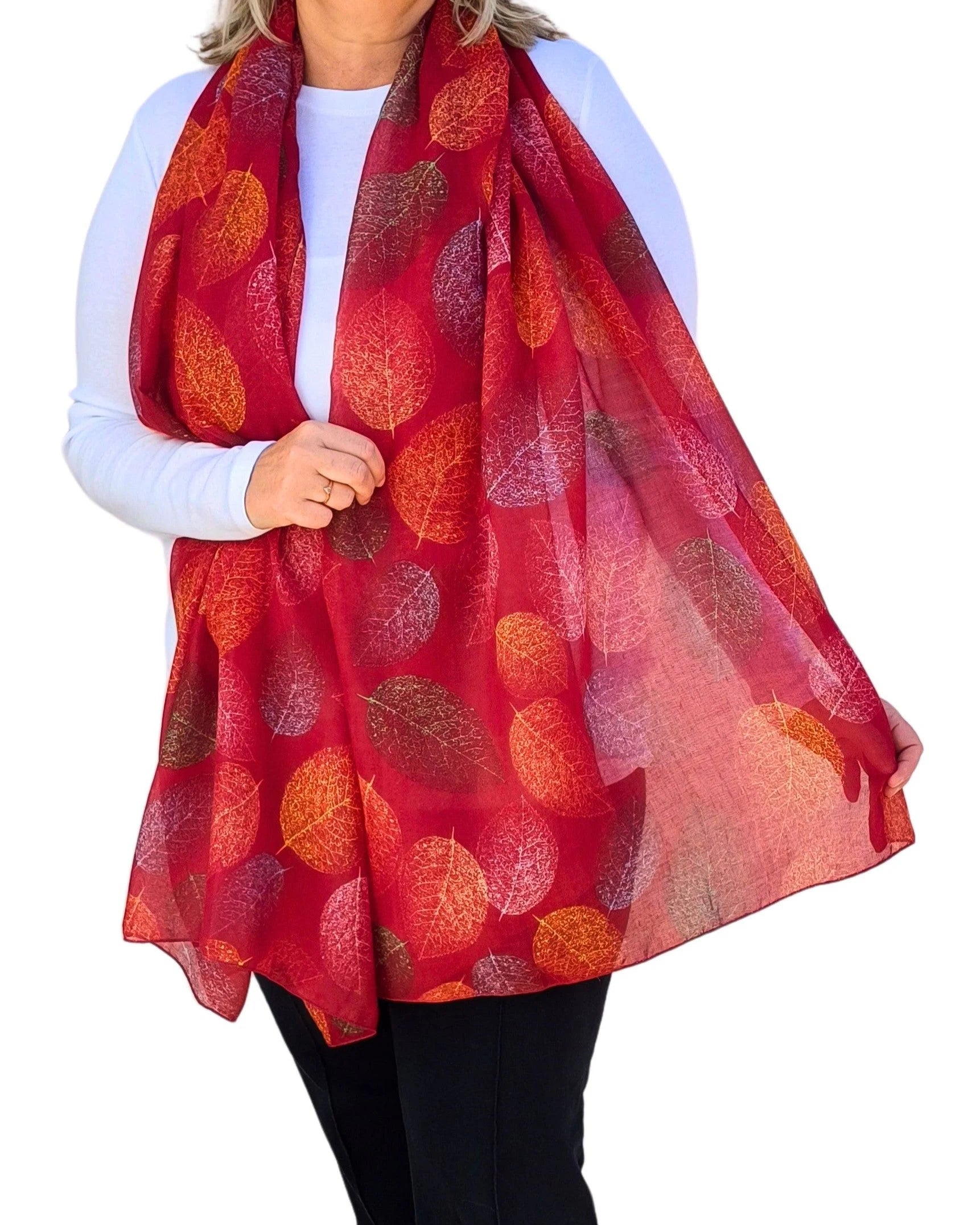 Lightweight red oversized scarf with autumn leaf pattern, modelled on white background