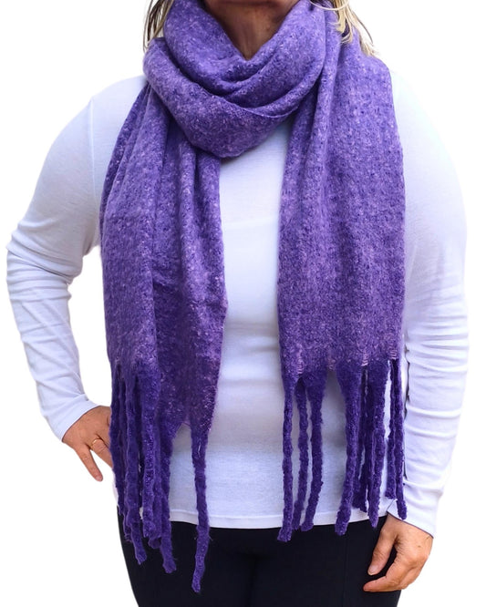 Aurora's Array: Woman models a soft, textured bright purple knit scarf with long fringe.