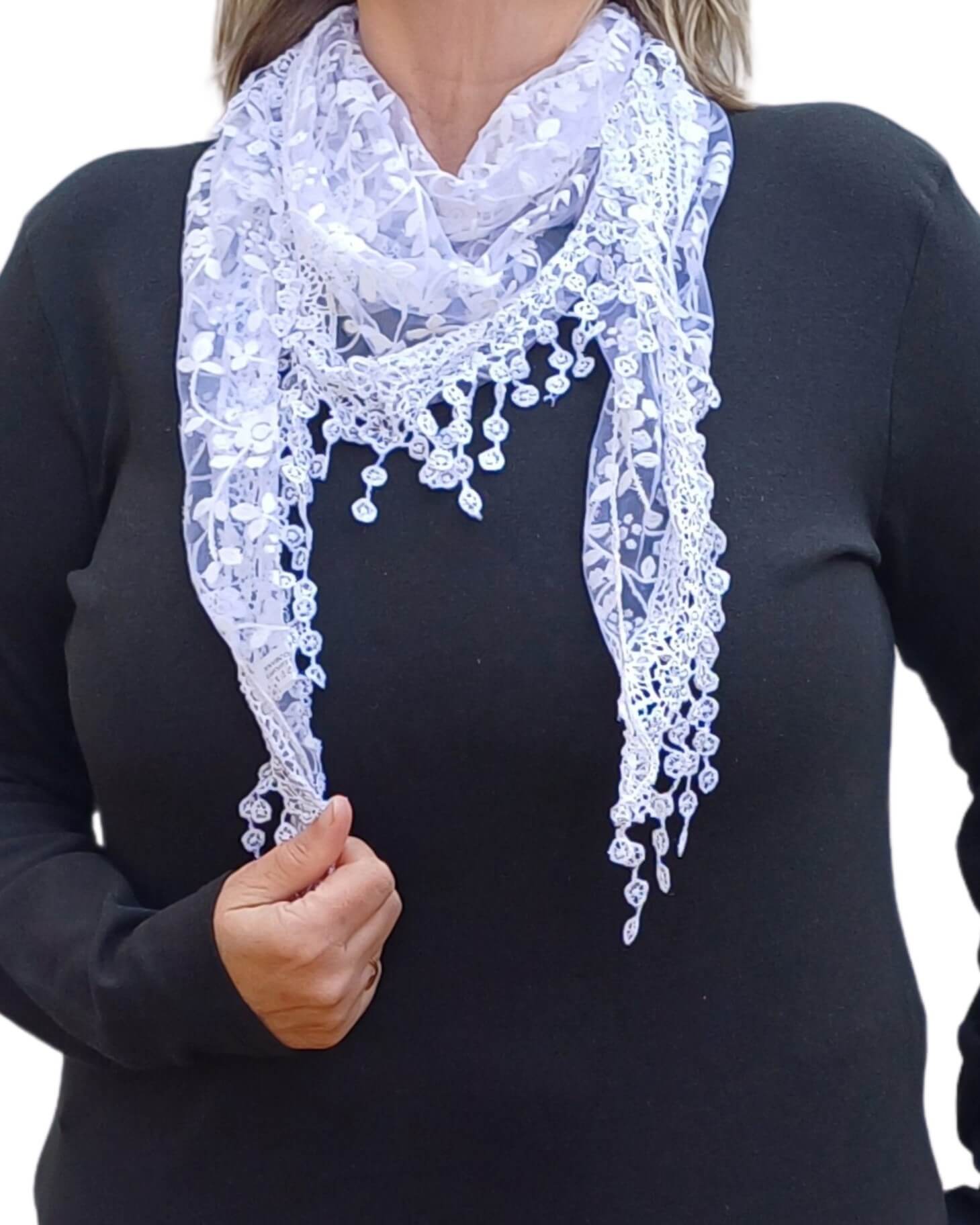 Aurora's Array Glitter Triangle Scarf with Lace & Embroidery: A woman models a white, sheer triangle scarf with a delicate white floral print, intricate lace trim, and dangling embroidered accents.