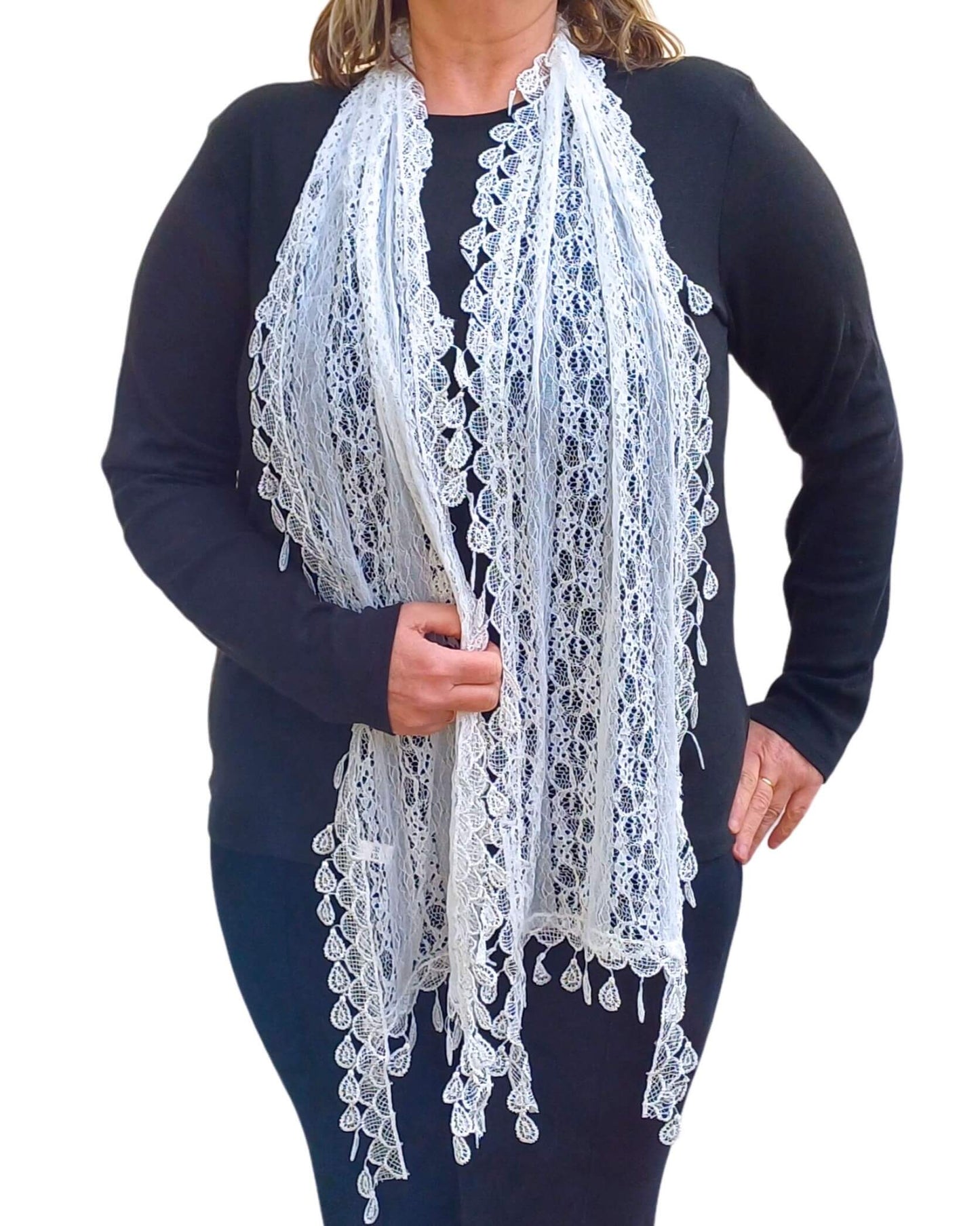 Aurora's Array: Woman models a delicate white lace scarf with an intricate floral pattern and scalloped edges.