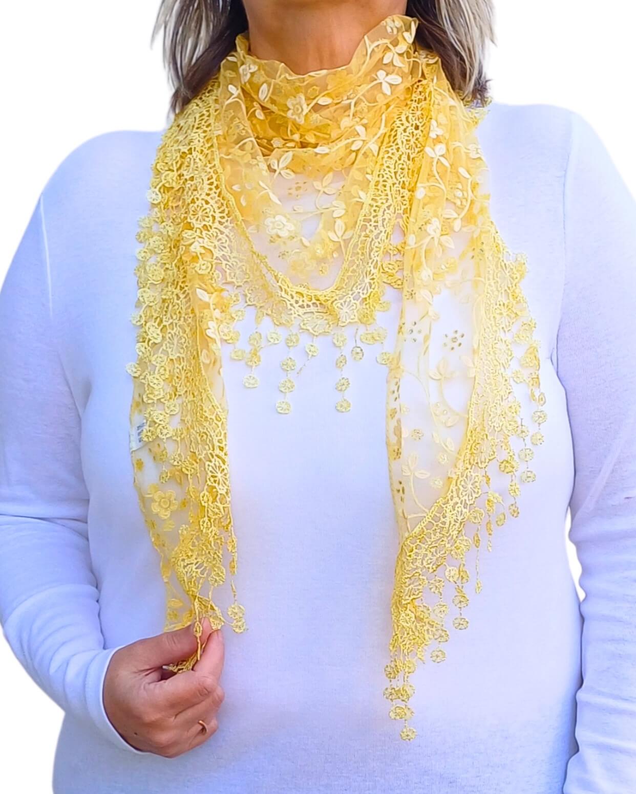 Aurora's Array Glitter Triangle Scarf with Lace & Embroidery: A woman models a bright yellow, sheer triangle scarf with a delicate white floral print, intricate lace trim, and dangling embroidered accents.