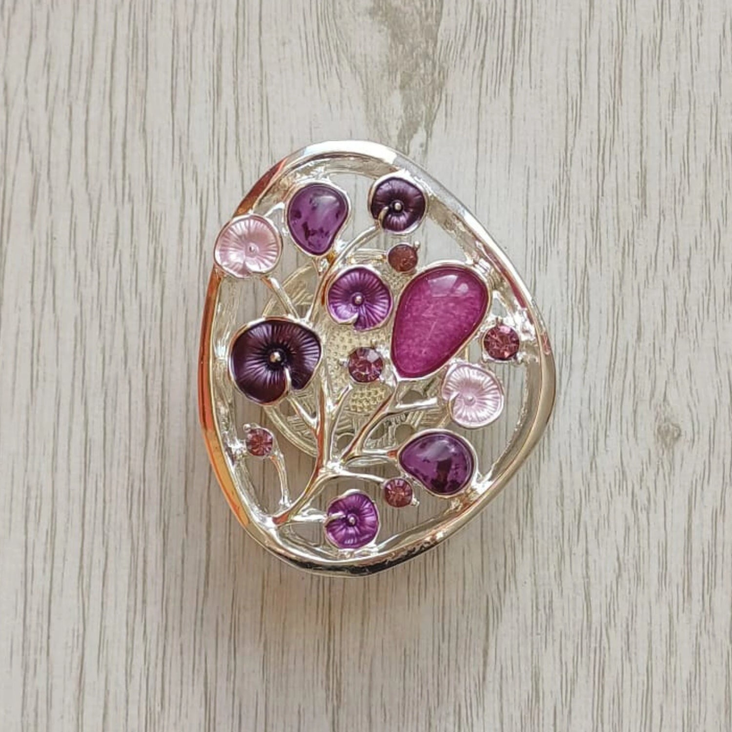 Purple Tree of Bloom magnetic brooch with painted metal finish on pale wood surface