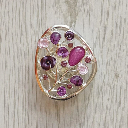 Purple Tree of Bloom magnetic brooch with painted metal finish on pale wood surface
