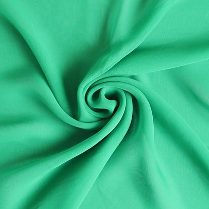 Bright green chiffon scarf swirled into a spiral, sheer lightweight fabric close-up – Aurora’s Array airy all-season accessory UK