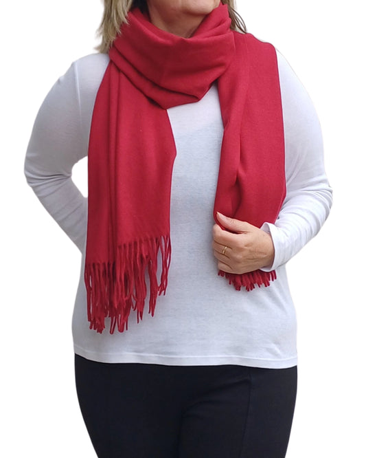 Cherry red cashmere blend scarf styled as a winter wrap, soft textured medium weight fabric, elegant plain finish