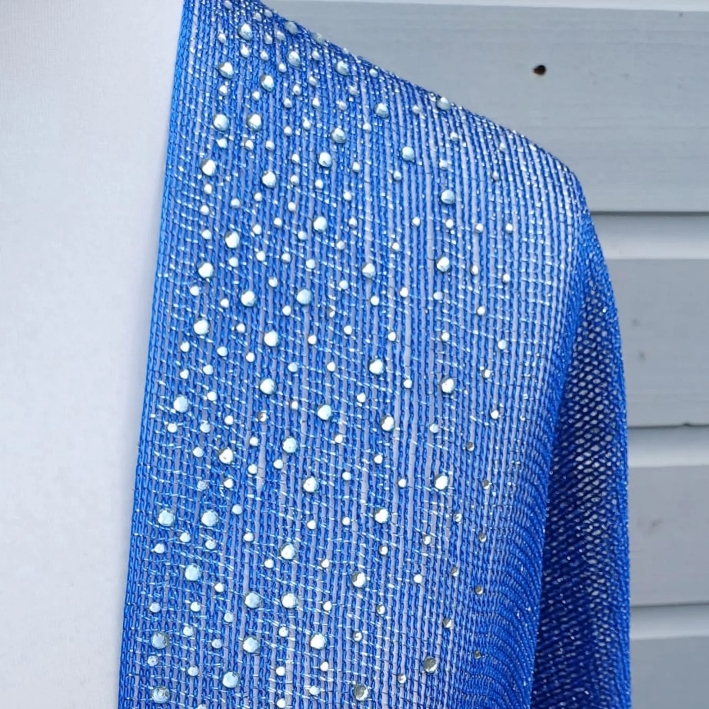 Cobalt blue sparkly kimono fabric with rhinestones and metallic lace texture shown close up