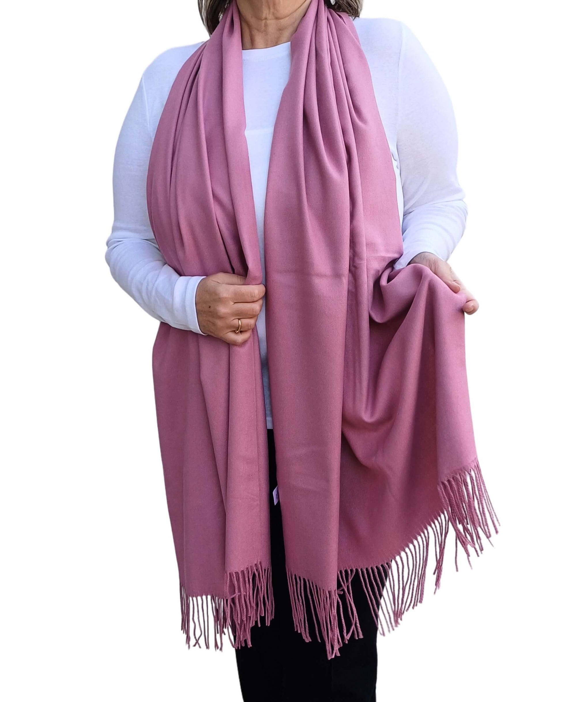 Dusky pink pashmina scarf with tassels, displayed full length on model.