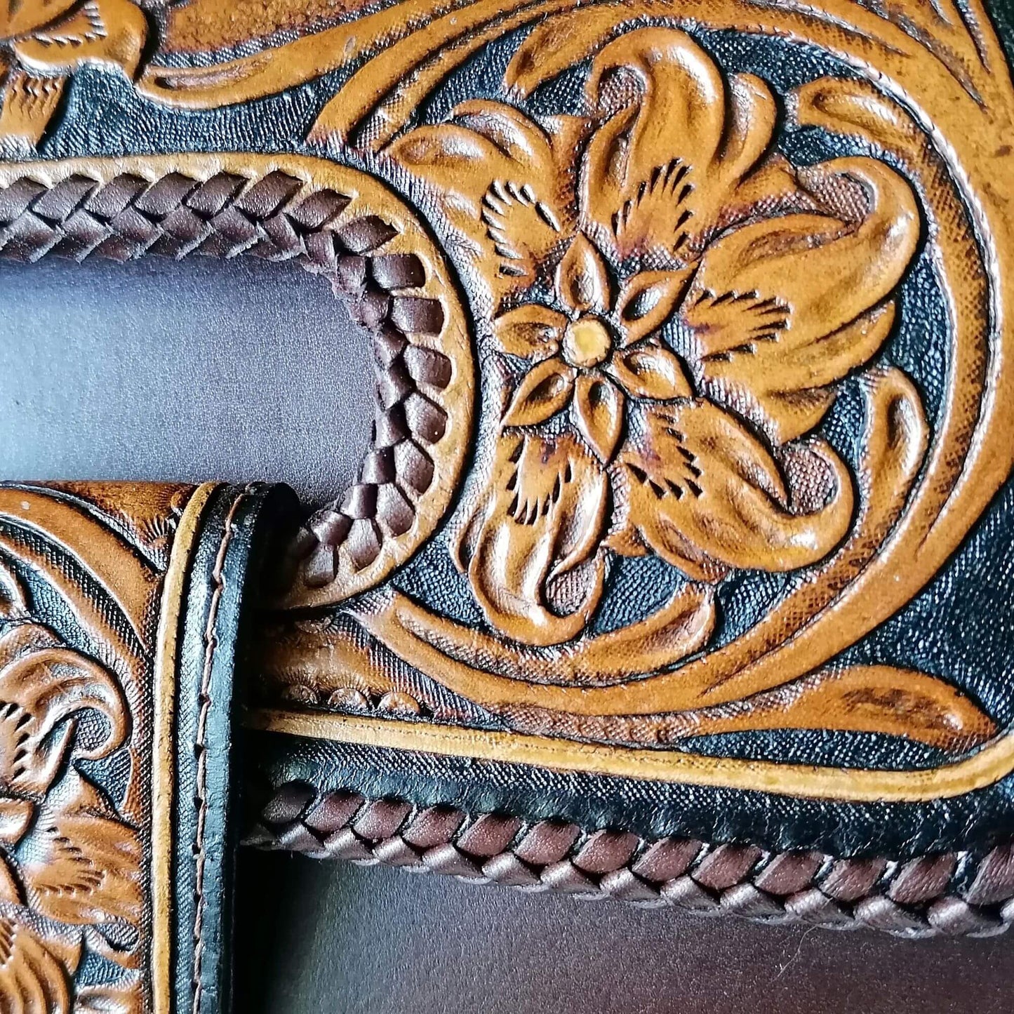 Detailed view of hand-tooled floral leather design on Elegancia bag