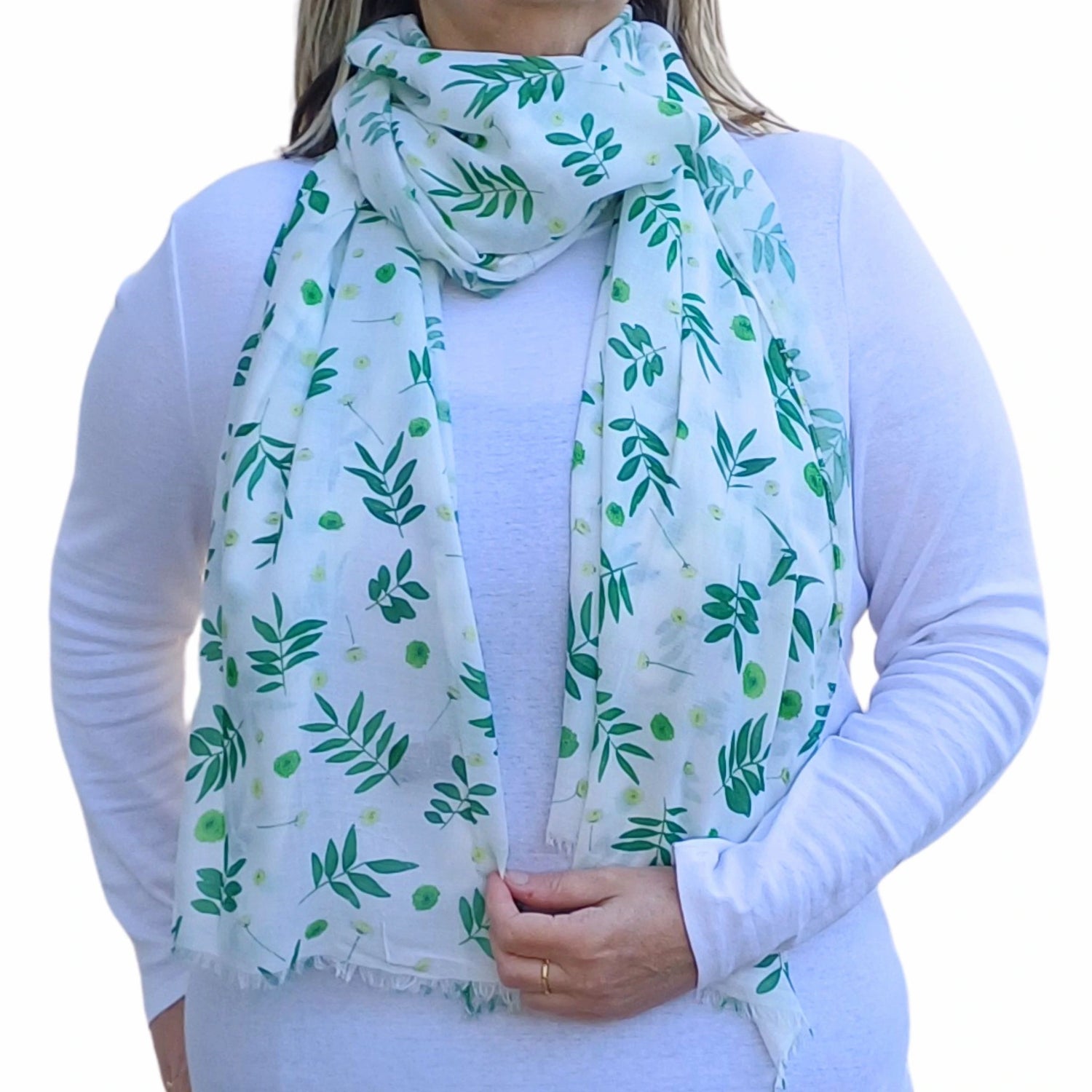 Person wearing a white scarf with green leaf pattern on a white background
