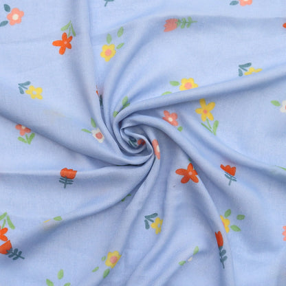 Soft light blue scarf with floral pattern in orange yellow and green swirled to show fabric texture