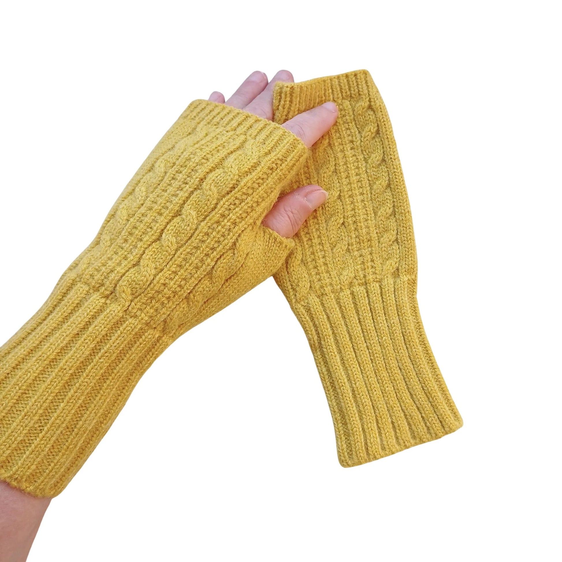 mustard wool blend cable knit fingerless gloves shown on hands against a white background