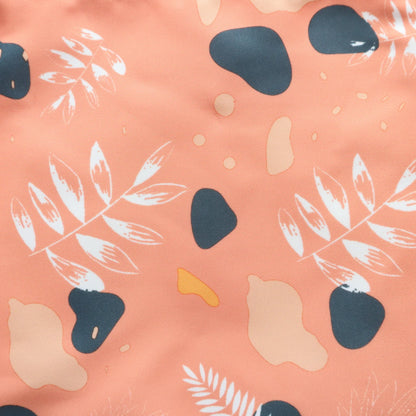 “Peach crossbody bag with modern abstract leaf and geometric print in navy and cream – textured fabric finish.