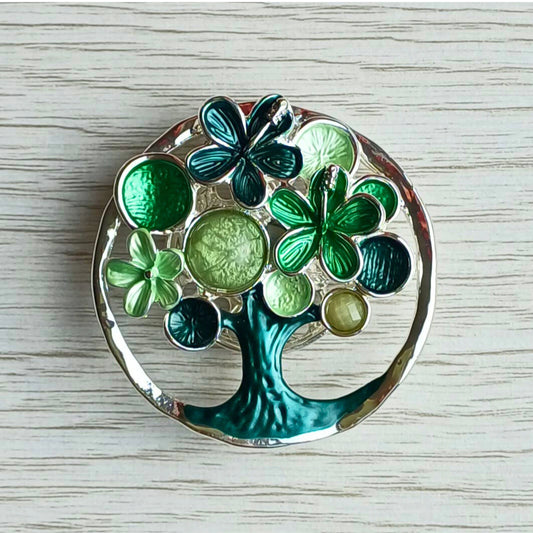 Blossom tree magnetic brooch in green decorative painted finish on a wooden surface.