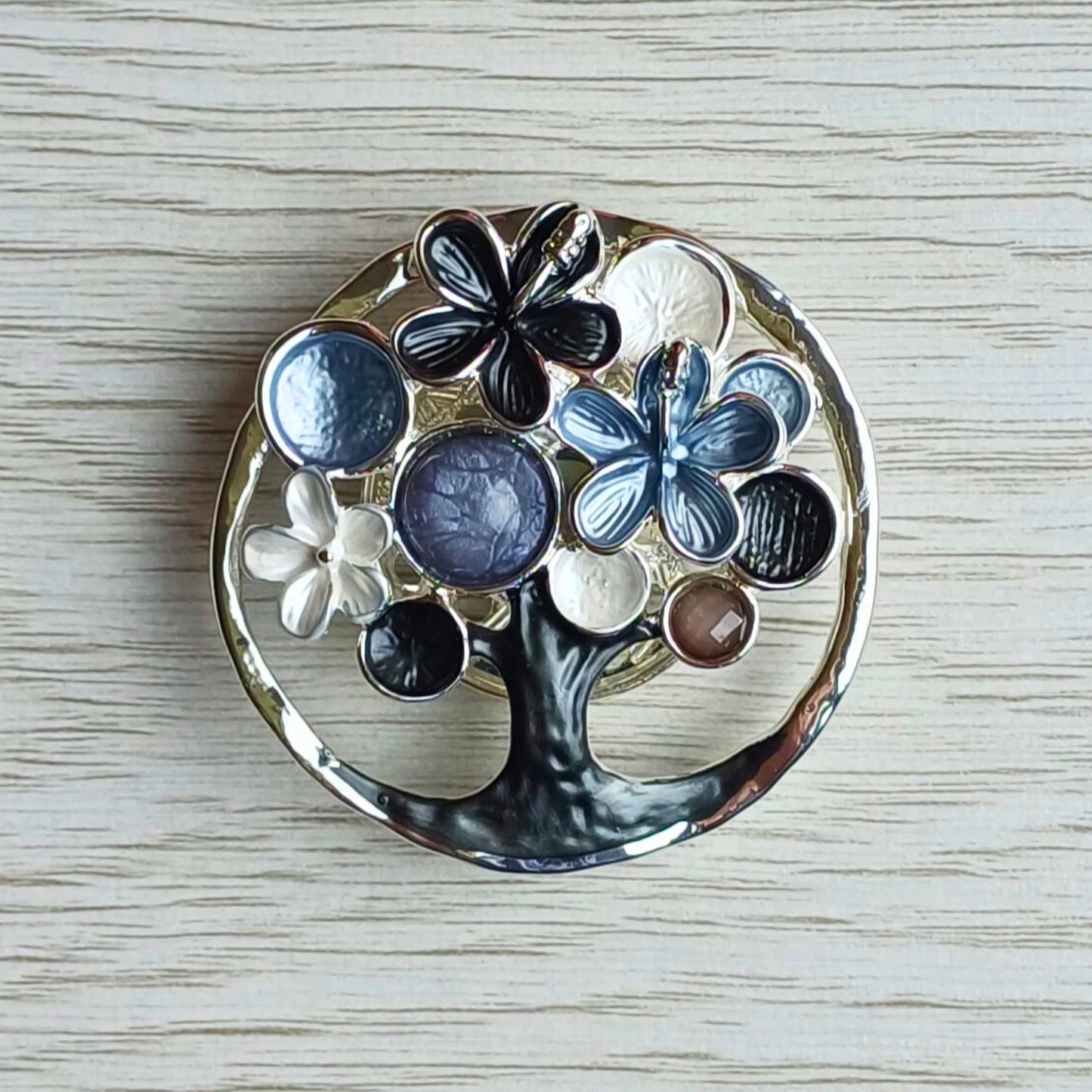 Blossom tree magnetic brooch in grey decorative painted finish on a wooden surface.