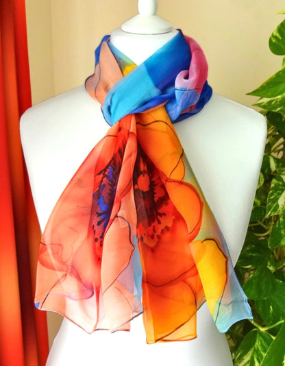 Vivid flower print chiffon scarf in orange and blue tones tied on mannequin