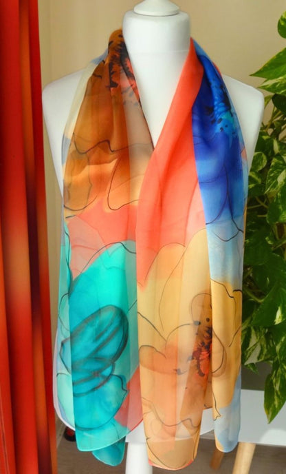 Light chiffon scarf with bold multicoloured floral pattern in coral, blue and gold displayed on mannequin