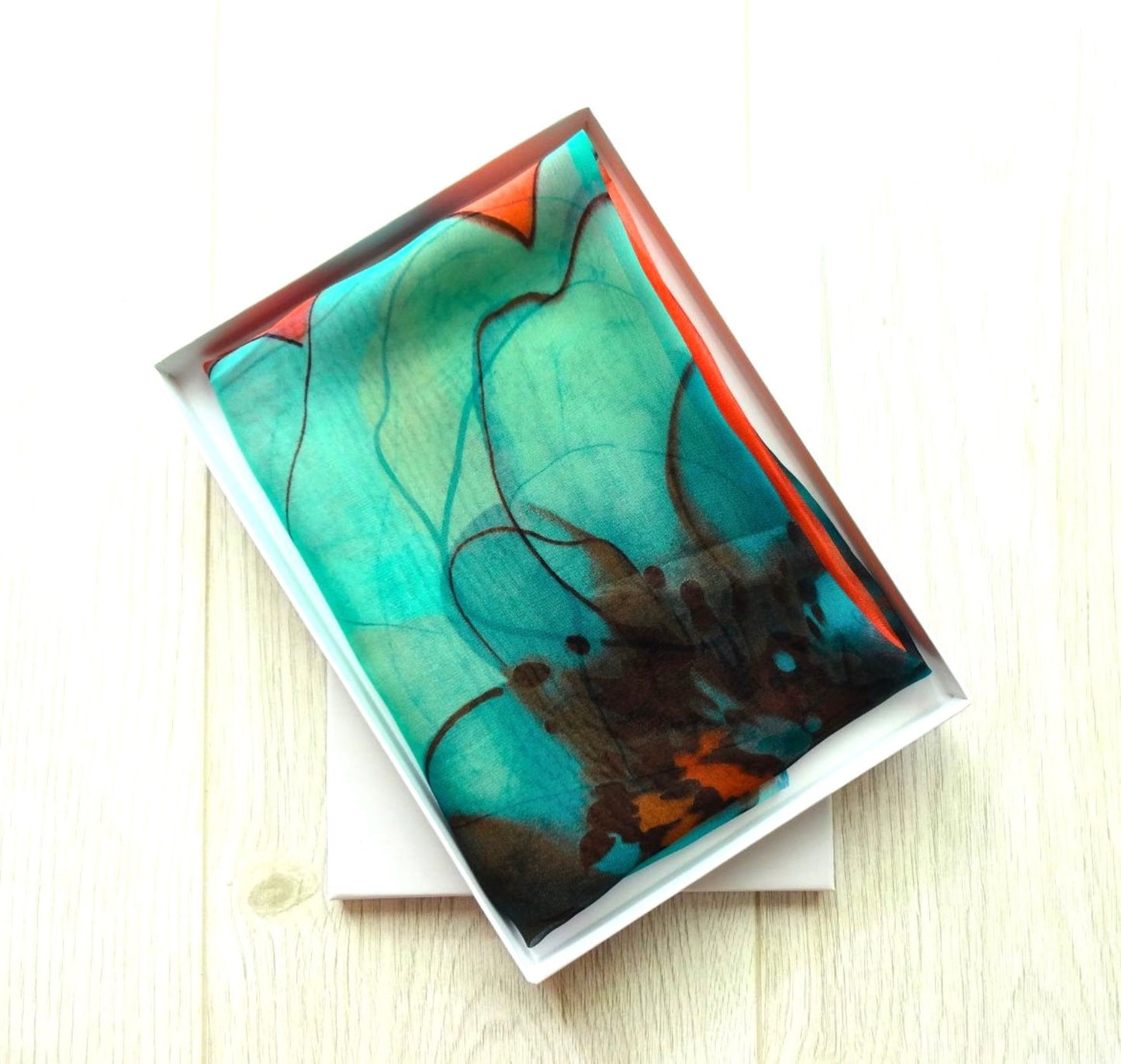 Lightweight chiffon scarf with teal and coral floral design neatly presented in a white gift box