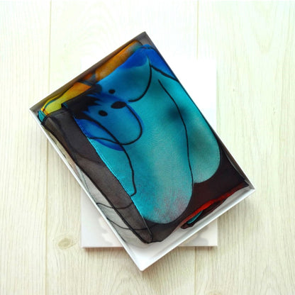 Colourful chiffon scarf with bold floral design folded in white gift box