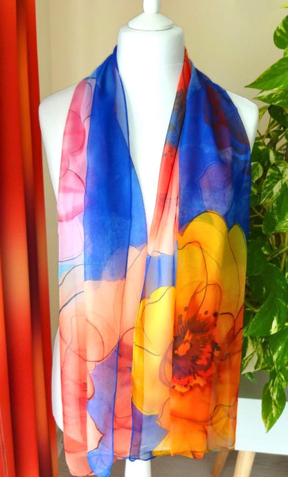 Bright chiffon scarf with large floral pattern in orange, yellow and blue draped over mannequin