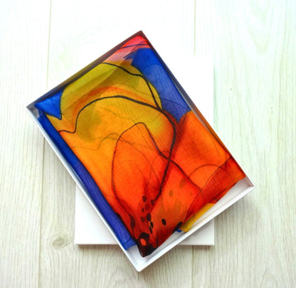 Lightweight chiffon scarf with vivid floral print neatly folded in a white gift box